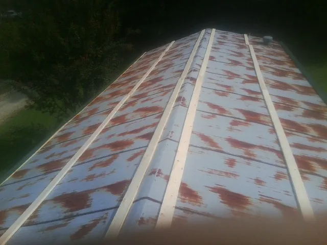 Rusted metal roof panels with new wood purlins before replacement — Storm Damage Roof Repair in East Sparta by Roofing Brothers