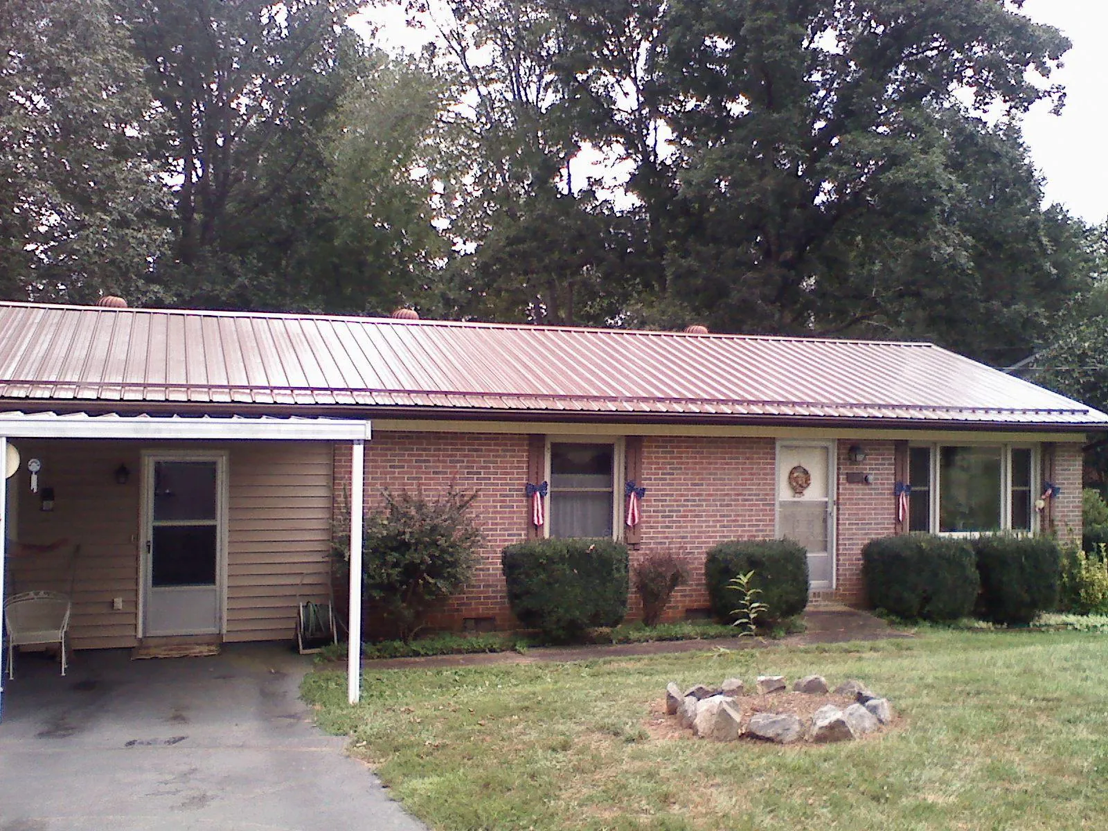 Bronze metal roof and carport on a brick ranch home — Roof Repair work by our crew in East Sparta
